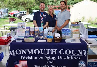 Monmouth County Employees from the Division on Aging, Disabilities &amp; Veterans Services behind their table at the resource fair